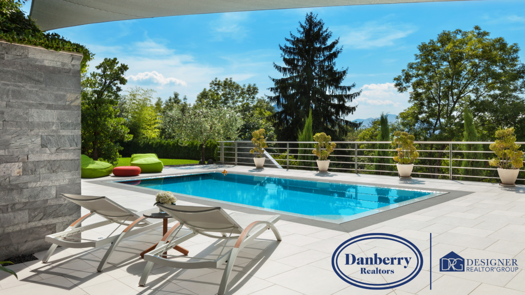 Luxury backyard patio with a sparkling blue swimming pool and lounge chairs under a bright summer sky in Findlay Ohio.