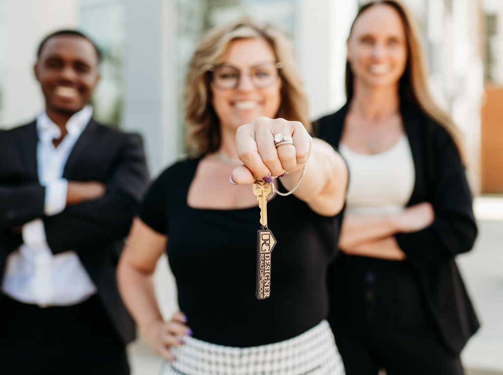 Designer Realtor Group team holding a DRG key