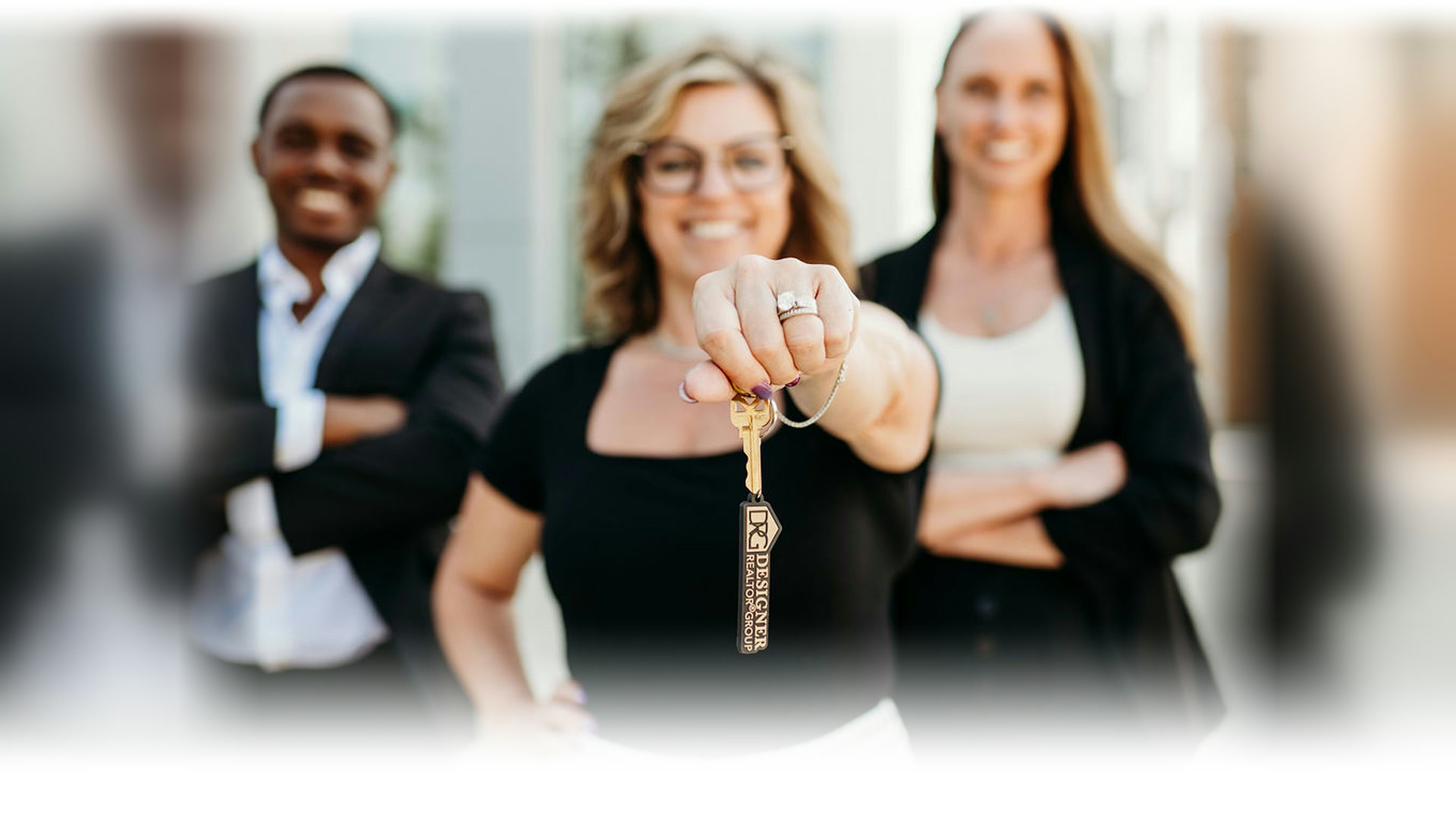 Designer Realtor Group team holding a DRG key